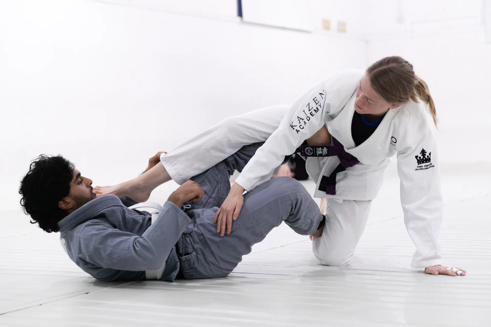 Gi BJJ partners practising a technique together at Kaizen Academy