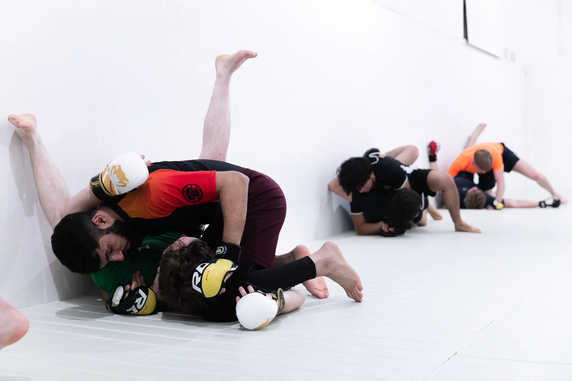 MMA partners practising ground positions with gloves at Kaizen Academy